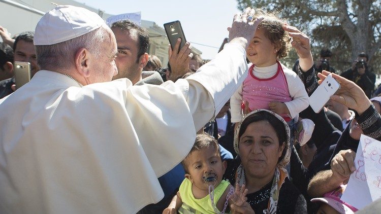 Papa Francisc salută copiii din tabăra de refugiați din Insula Lesbos.