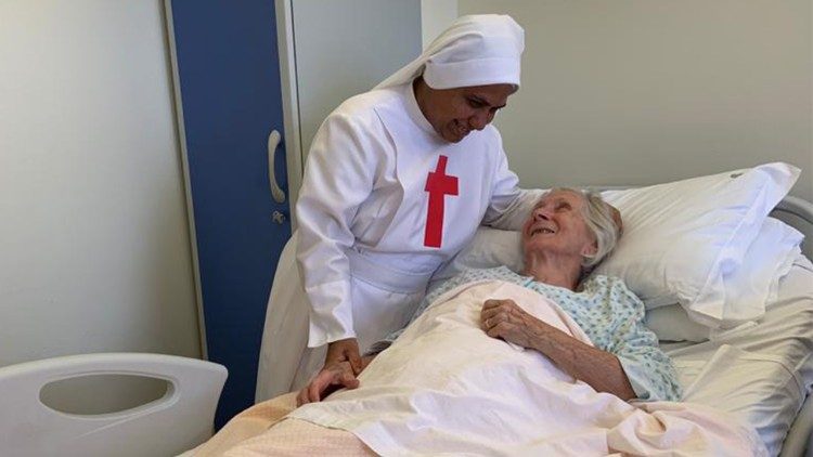 Một nữ tu dong thánh Camillo bên cạnh một bệnh nhân