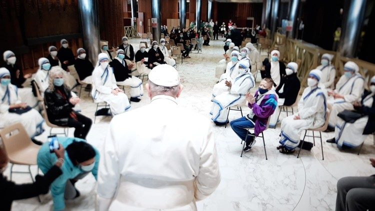 The Pope pauses to speak to a group of volunteers and nuns
