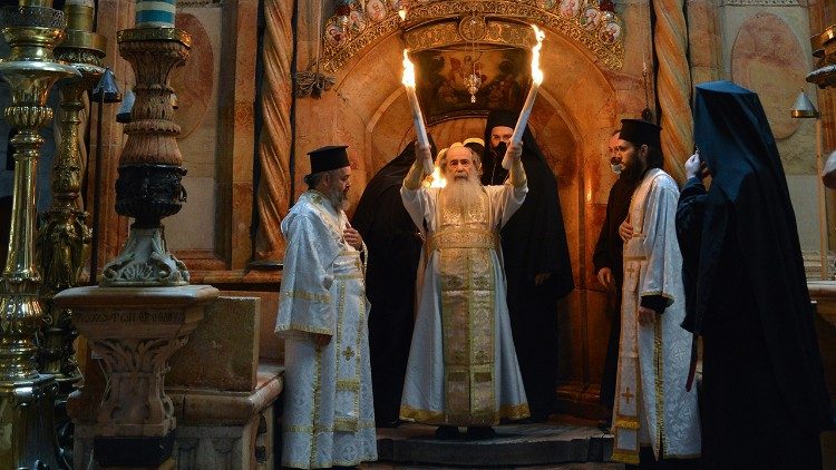 El Patriarca Ortodoxo Griego de Jerusalén muestra a los fieles los dos haces de velas con el Fuego Sagrado. Foto Nadim Asfur