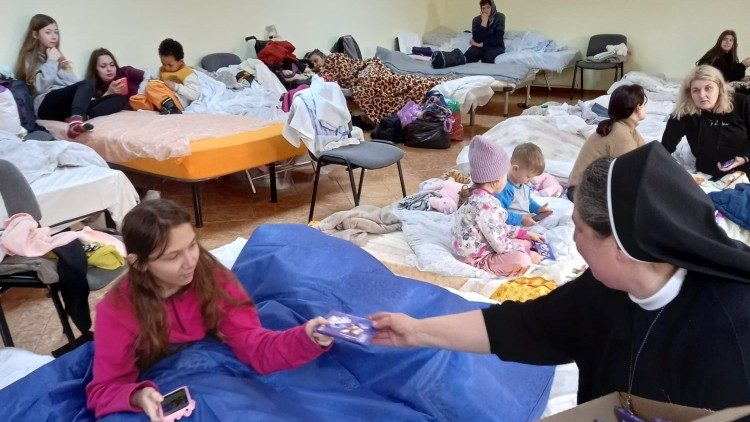A nun distributes chocolate to young Ukrainian refugees