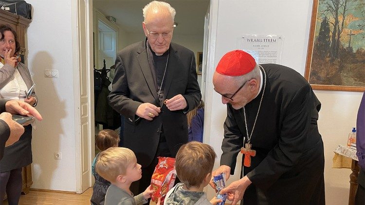 Two children offer the Cardinal some snacks