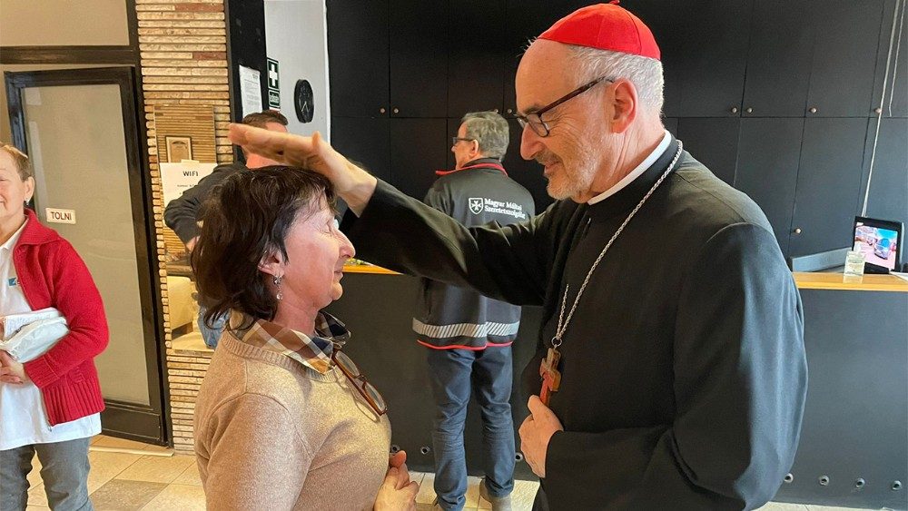 Le cardinal bénissant une réfugiée