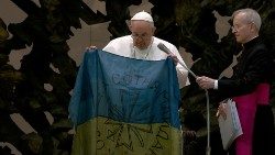 Na Audiência Geral de 6 de abril de 2022, Papa Francisco mostra a bandeira ucraniana proveniente de Bucha
