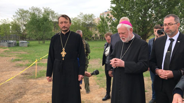 Archbishop Gallagher bows his head in prayer during a visit to Ukraine in 2022
