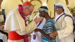 Il cardinale Pietro Parolin accarezza una bambina malata durante l'incontro nella Nunziatura di Kinshasa con le Congregazioni religiose locali