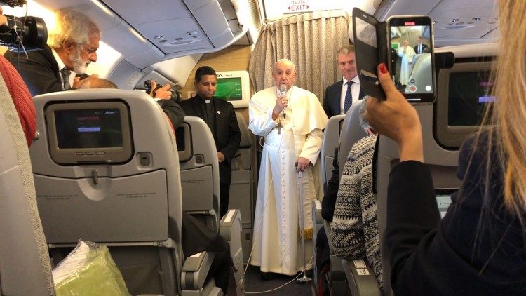 Pope Francis greeting journalists during the papal flight to Canada