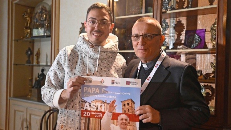 Fabio Celestre (a sinistra) con il vescovo di Asti Marco Prastaro e il manifesto della visita del Papa da lui ideato