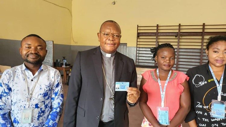Le cardinal Fridolin Ambongo, archevêque de Kinshasa, avec quelques agents du centre d’enrôlement de l’école Saint-Raphaël de Limété - Kinshasa, mardi 27 décembre 2022.