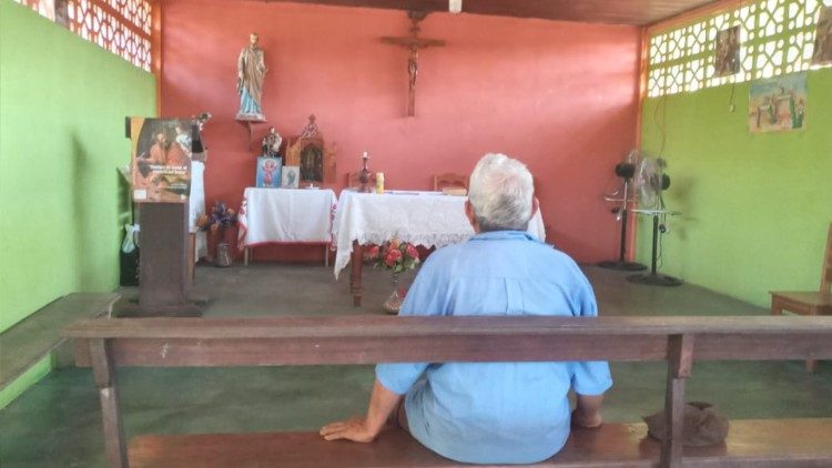 Un sénior prie dans la communauté paysanne de San José