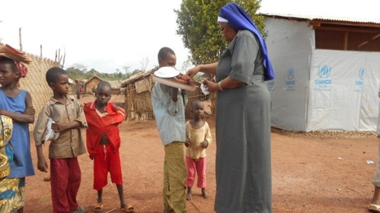 Suor Alphonsa distribuisce caramelle ai ragazzini alla fine della scuola