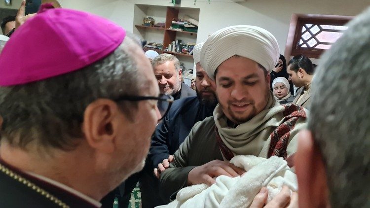 A baby born in the days of the earthquake is presented to Archbishop Gugerotti