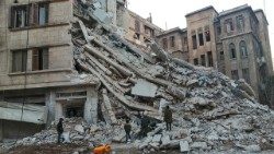 Restos de um edifício que desabou parcialmente em Aleppo durante o terremoto do dia 06/02/2023.  Na foto, crianças recolhem madeira que será usada para o aquecimento durante o duro inverno em Aleppo. 