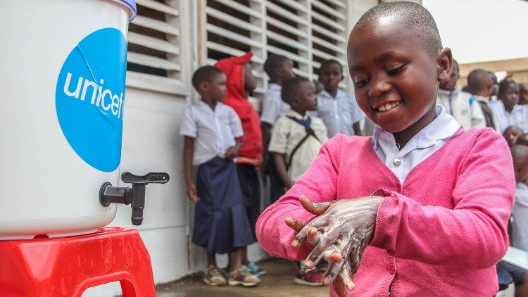 Clarisse, 10, aluna de uma escola primária apoiada pelo UNICEF em Beni, mostra a seus colegas como lavar as mãos corretamente.