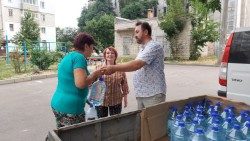 Le père Taras Pavlius distribuant de l'eau.