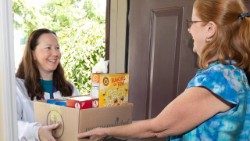 A irmã Jennifer entrega um pacote de géneros alimentícios