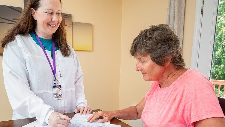 Sœur Jennifer explique à un patient les programmes de transition entre l'hôpital et le domicile (avec l'aimable autorisation de Catholic Charities de la Virginie-Occidentale.).