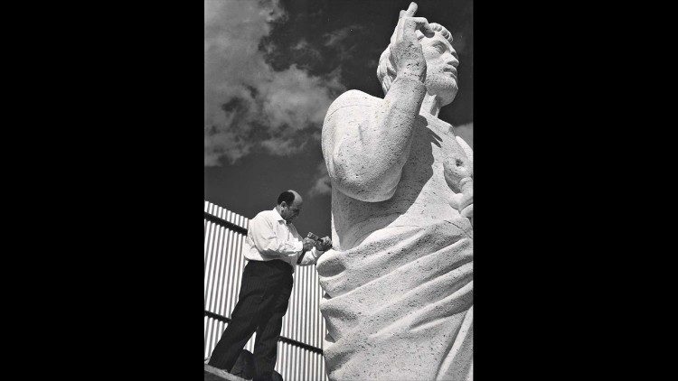 Domenico Ponzi mentre scolpisce la statua di Pietro all'esterno della chiesa dei SS. Pietro e Paolo