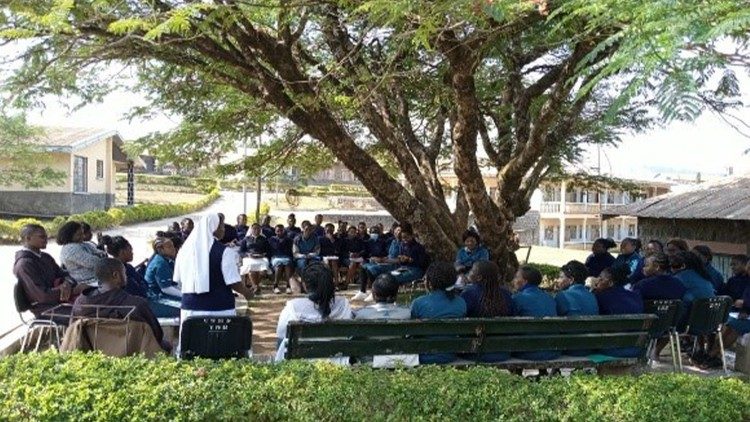 Estudiantes reunidos en oración y reflexión en la naturaleza frente a la Catholic School of Health Sciences