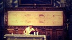 Monsignor Giuseppe Ghiberti con alle spalle il telo della Sindone