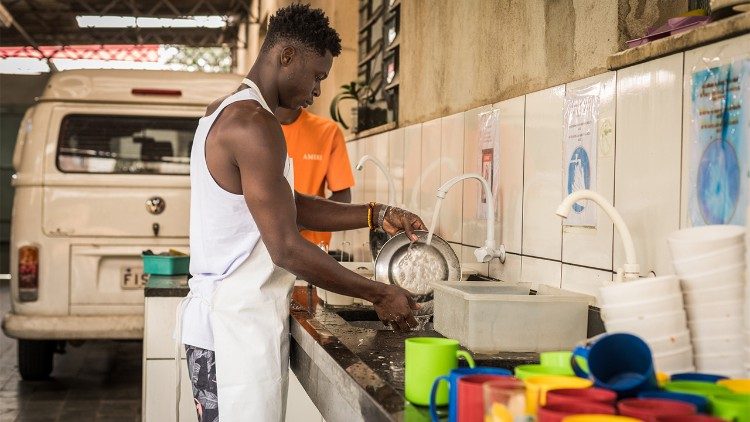 Tras el almuerzo junto personas de distintas partes del mundo, John Ekow colabora lavando los platos en la Casa del Migrante de Sao Paulo, Brasil. (Giovanni Culmone/Global Solidarity Fund)