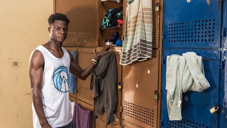 En Costa de Marfil John Ekow trabajaba como mecánico automotriz. Ahora espera ansioso conseguir ropa adecuada que le permita ensuciarse mientras repara vehículos. (Giovanni Culmone/Global Solidarity Fund)