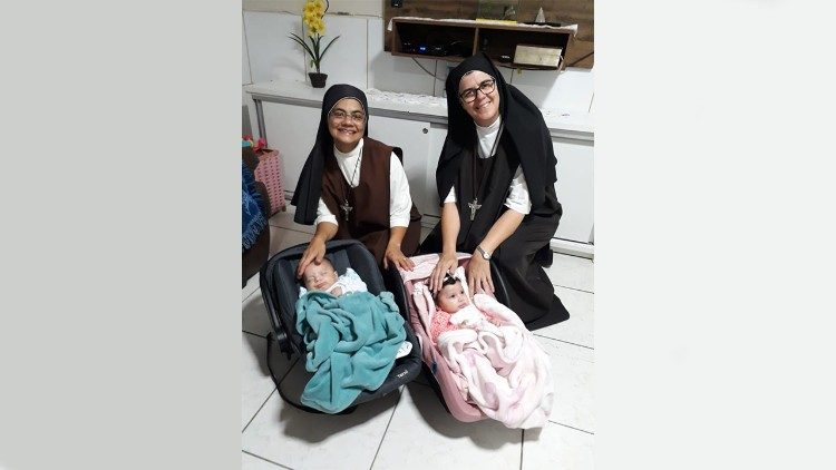 Duas Carmelitas Mensageiras do Espírito Santo com duas crianças hospedadas no Lar