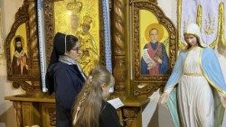 Sister Anastasia Zabrodska prays with a young woman in Odessa