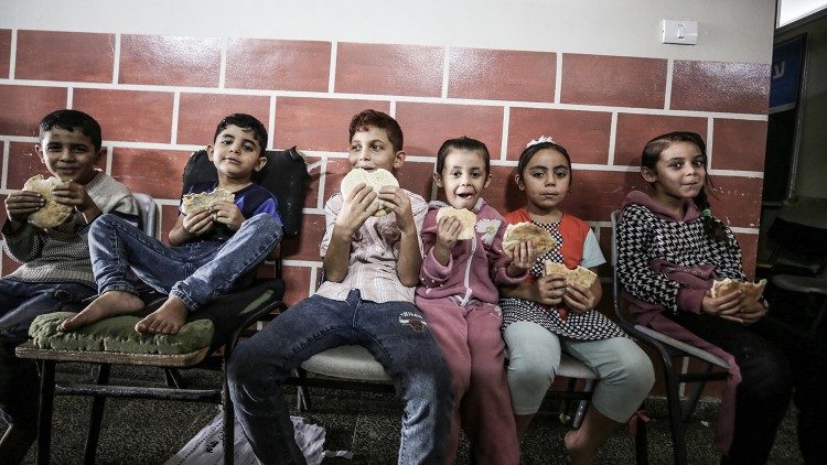 Bambini in un rifugio di Gaza mangiano il pane prodotto dai panifici convenzionati con il Pam-Wfp
