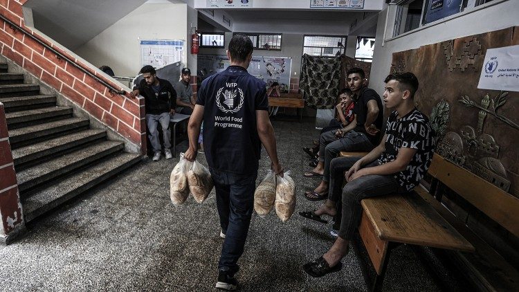 Un operatore del Wfp-Pam porta pane in un rifugio di Gaza