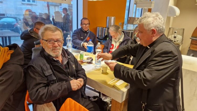 Cardinal Krajewski having lunch with some users of the service