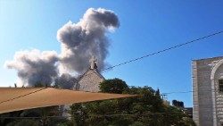 Gaza, la croce di una chiesa avvolta dal fumo di un'esplosione