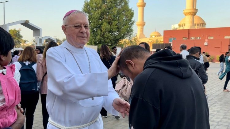 Mons. Paul Hinder vicario emerito dell' Arabia del Sud benedice un fedele. Sullo sfondo una delle tante moschee di Abu Dhabi