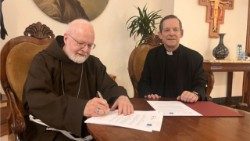 Kardinolas Seanas O’Malley OFM ir kun. Luisas Navarro pasirašo susitarimą