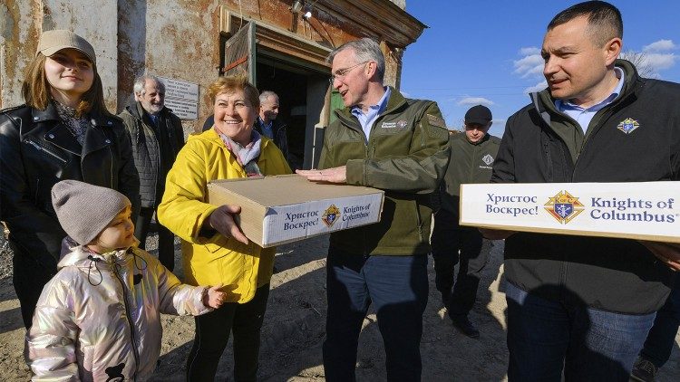 Najwyższy Rycerz Patrick E. Kelly (w środku) i Delegat Stanowy Rycerzy Kolumba w Ukrainie Jurij Malecki rozdają paczki wielkanocne ukraińskim uchodźcom w Rawie Ruskiej w kwietniu 2022 r. (Andrij Gorb)