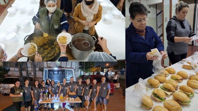 Freiwillige Helfer, darunter auch Ordensschwestern, servieren Mahlzeiten, bereiten Sandwiches zu und richten den Tisch für die Verteilung der Mahlzeiten und Snacks an Obdachlose vor dem Notfallkrankenhaus von Canoas.