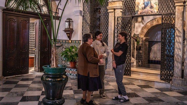 Saleha conversa entusiasticamente com a psicóloga que a acompanha e com uma das irmãs franciscanas do Rebanho de Maria na casa onde está morando há um ano. (Giovanni Culmone / Global Solidarity Fund)