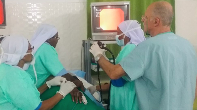 A doctor and nurses perform a sonogram on a pregnant woman