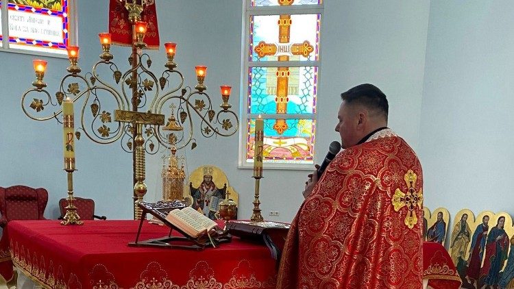 Padre Roman Mykievych durante um funeral 