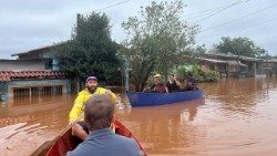De barco, Pe. João Vitor leva apoio espiritual aos atingidos pelas enchentes na Diocese de Montenegro. (Foto: Pascom da Paróquia Sagrado Coração de Jesus)