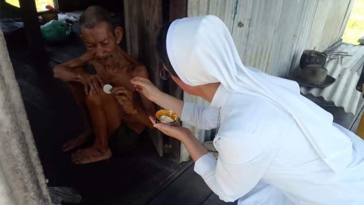 Sister Marcia brings Communion to the sick on the Island of São Sebastião, in the Amazon, Brazil