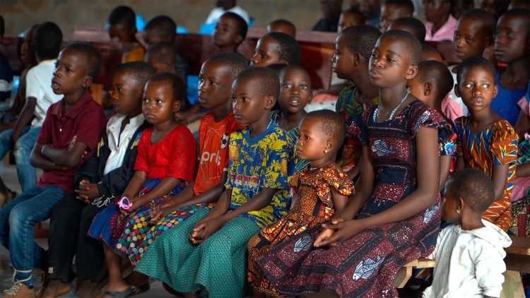 Children sit together at Mass