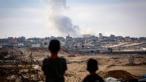 Crianças observam a fumaça que se espalha durante ataques israelenses a leste de Rafah, no sul da Faixa de Gaza, em 13 de maio de 2024 (AFP)
