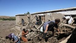 洪水に襲われた家から流木等を取り除く人々　2024年5月13日　アフガニスタン北部バグラン州で